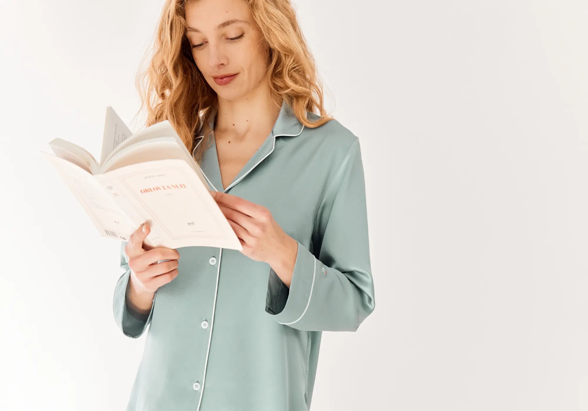Femme lisant un livre en pyjama en soie Maison CÉTOILE lors d'un rituel du soir
