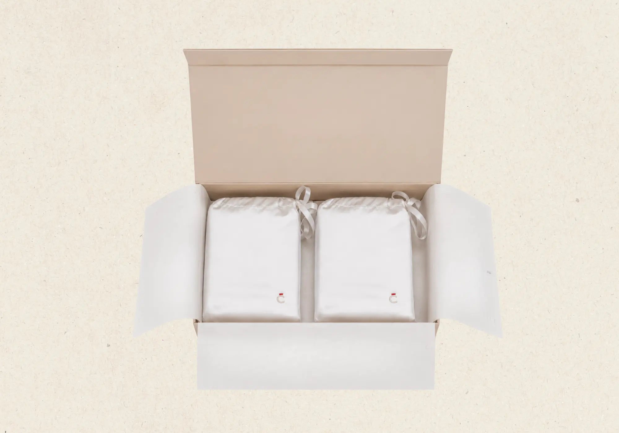 Boîte Maison CÉTOILE contenant deux pochons réutilisables en tissu ivoire, illustration d’un packaging durable et soigneusement conçu.