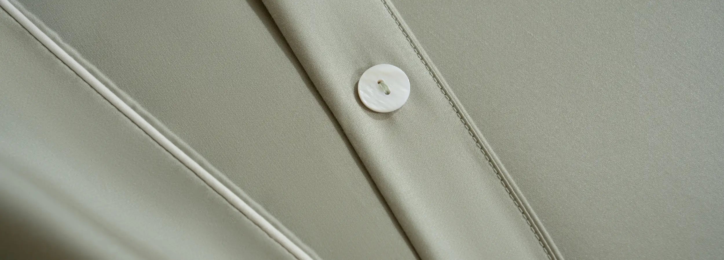 détail bouton en nacre et passepoil blanc de la housse de couette verte sauge signé Maison CÉTOILE
