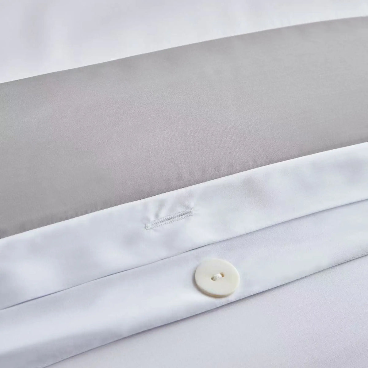 Gros plan sur le liseré gris et les boutons de finition de la parure Gris Horizon en TENCEL™ Lyocell.