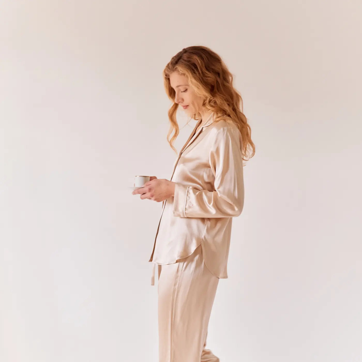 Femme portant un pyjama en soie de mûrier 22 momme couleur champagne, confection haut de gamme Maison CÉTOILE.