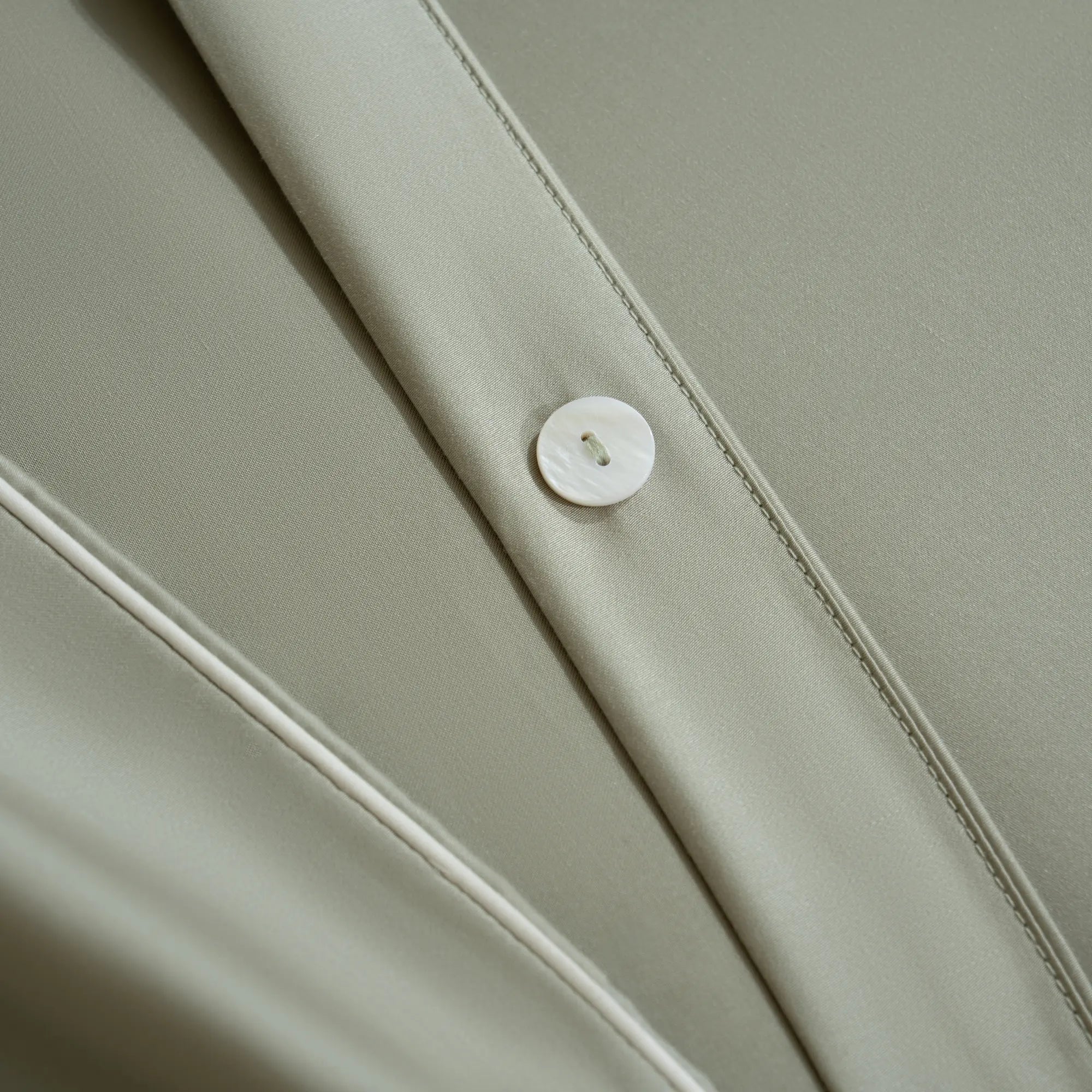 details de bouton en nacre et passepoil blanc de la parure Brume verte signé Maison CÉTOILE