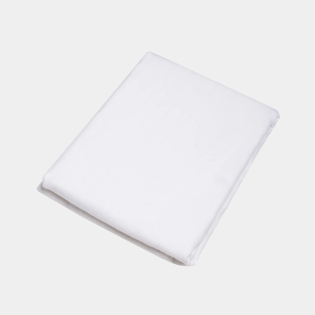Drap-housse Éveil Blanc en lin lavé français plié sur fond blanc