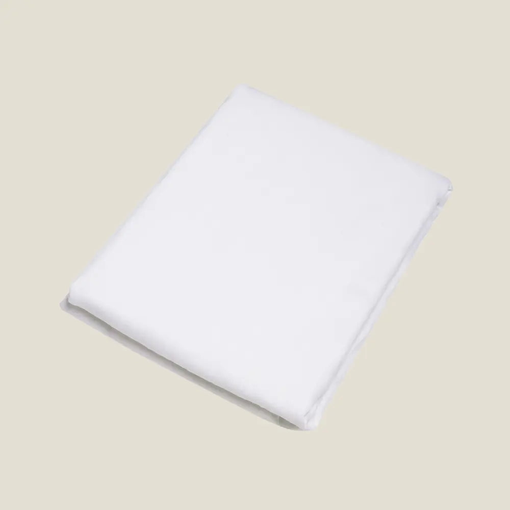 Drap plat Éveil Blanc en lin lavé français plié sur fond beige