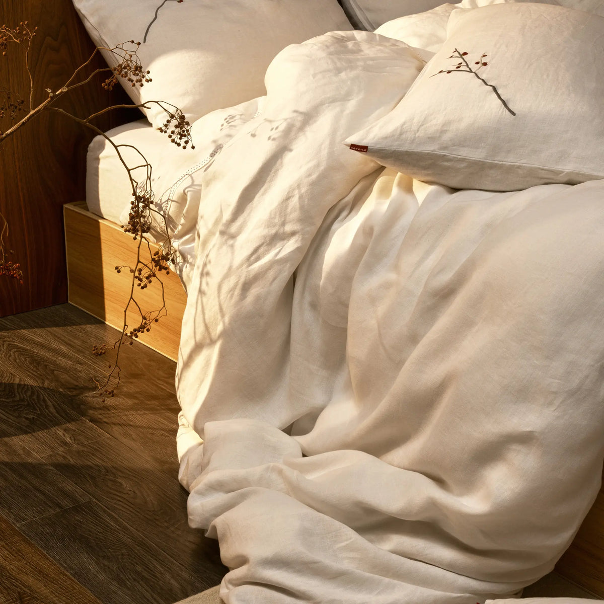 Drap plat Éveil Blanc en lin lavé français disposé sur un lit aux tons naturels