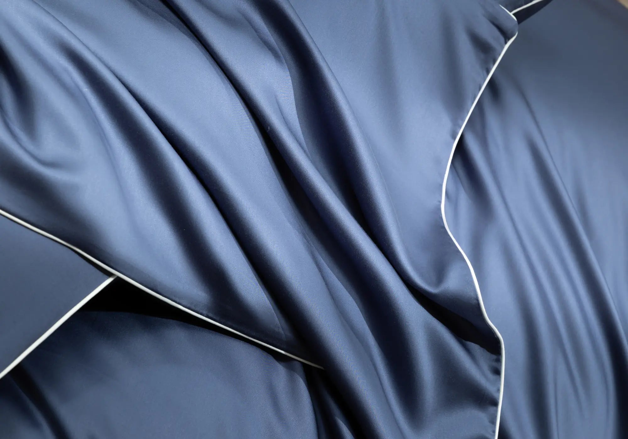 Gros plan sur le linge de lit Apès Minuit en TENCEL™ Lyocell Maison CÉTOILE, mettant en valeur le drapé fluide et le toucher soyeux de la matière.