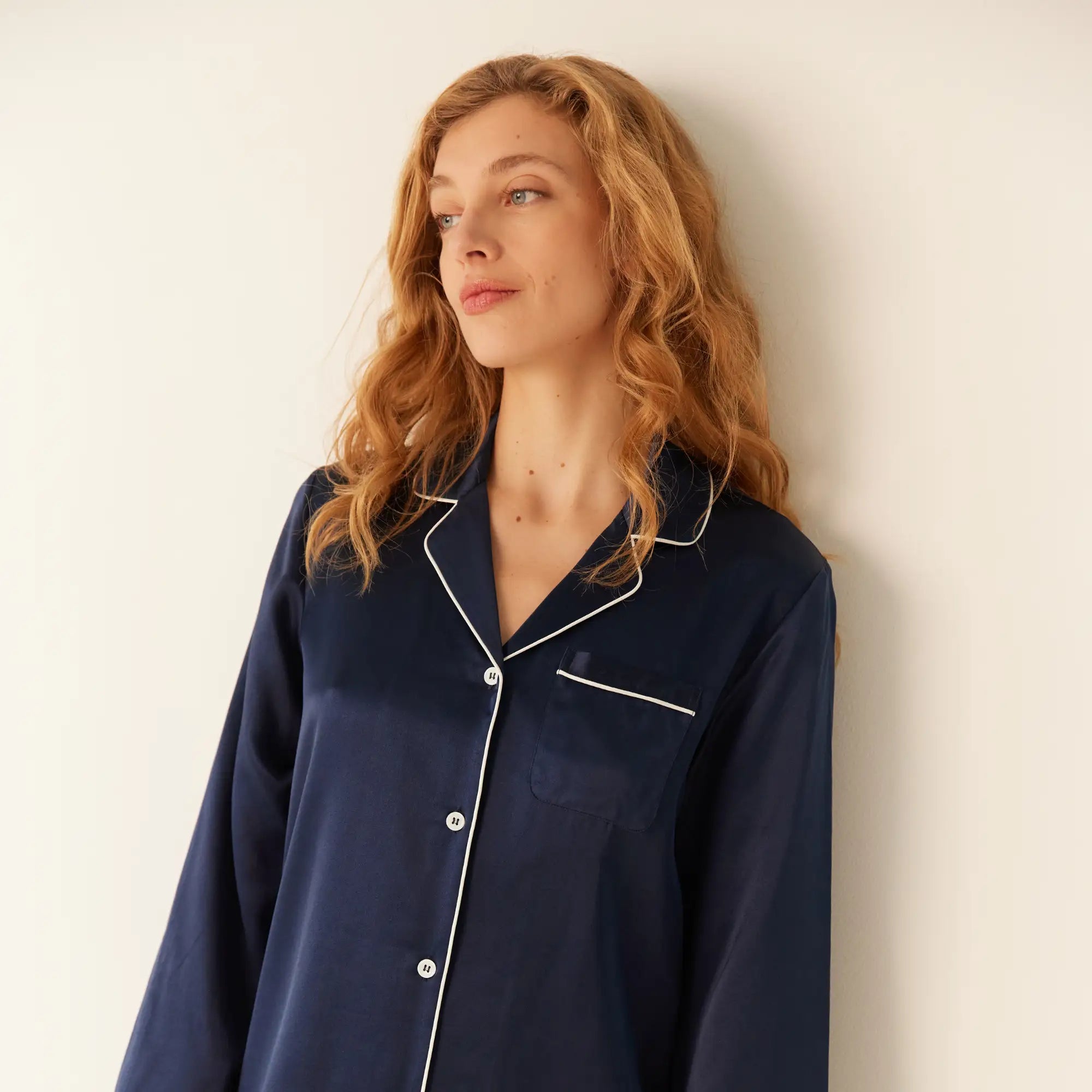 Femme portant le pyjama en soie de mûrier Heure Bleue de Maison CÉTOILE, bleu nuit à passepoil blanc.