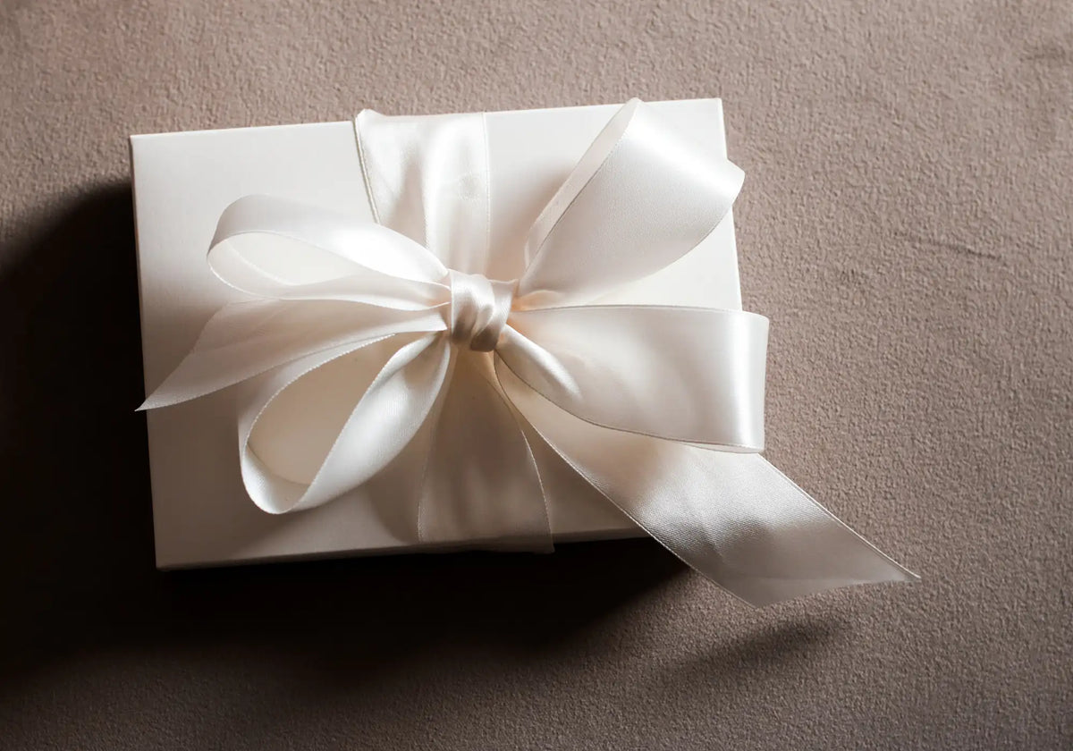 Coffret cadeau élégant noué d’un ruban de satin ivoire