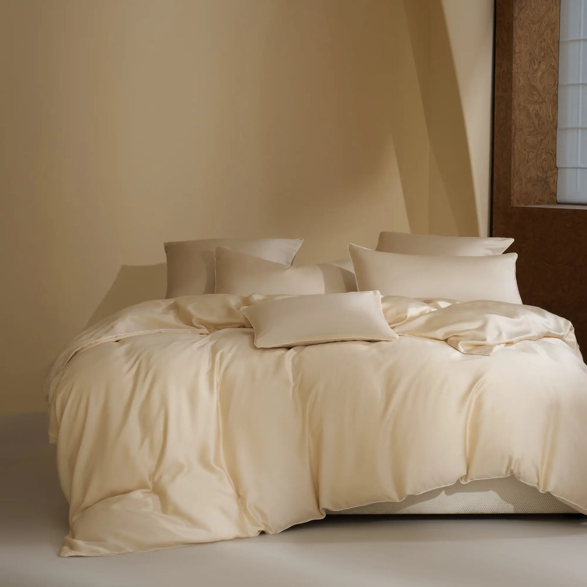 Parure de lit Voile d’Aube en TENCEL™ Lyocell ivoire, présentée sur un lit complet.